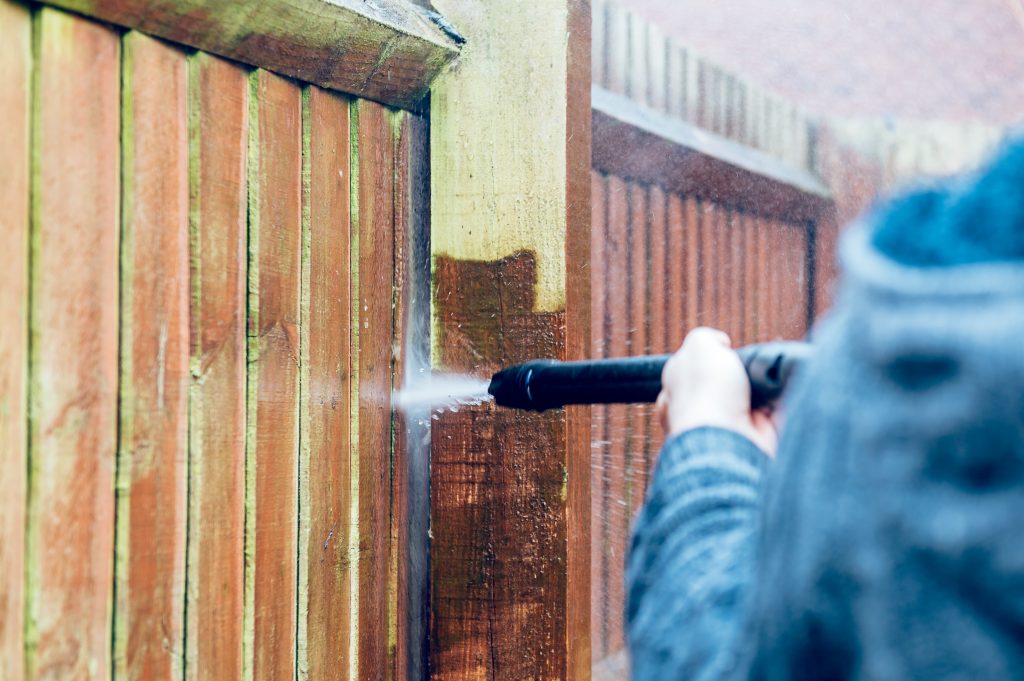 Pressure Washing Before Painting, Cleaning and Renovating Wood Fence with powerful jet wash or pressure washer, spring cleaning of the garden and house