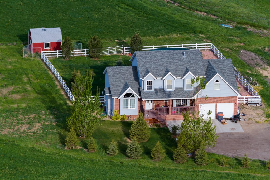 Aerial view of Indiana light blue siding and red brick farmhouse for ready for updated modern farmhouse paint colors